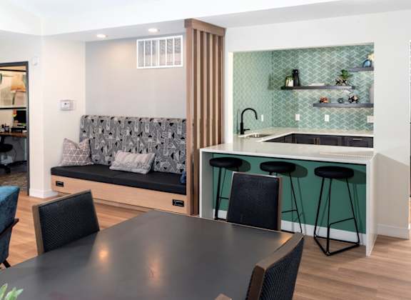 a kitchen with a black dining table and four black chairs