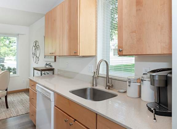 a kitchen with white countertops and wooden cabinets