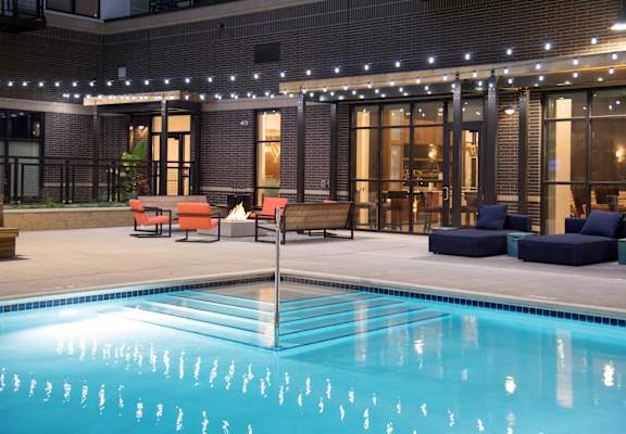 A pool with a chair and lights above it.