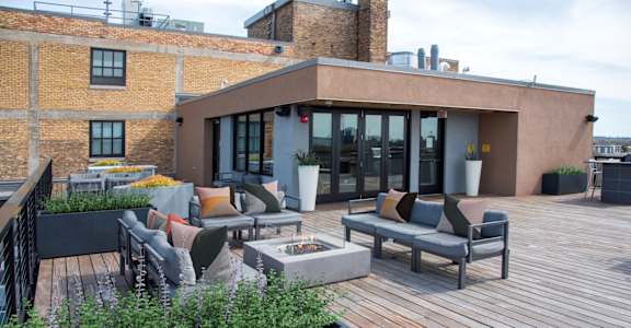 A patio with a table and chairs is surrounded by a brick wall.