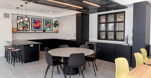 a dining room and kitchen with yellow chairs and a table