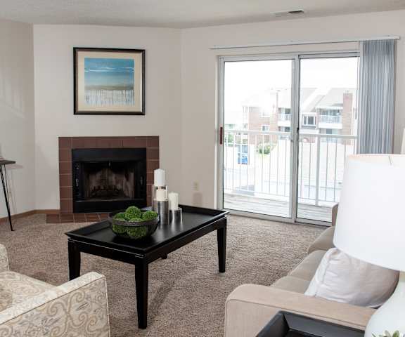 A living room with a fireplace and a painting on the wall.