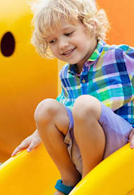 A child is playing on a yellow slide.