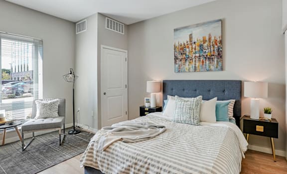 A bedroom with a large bed and a painting on the wall.