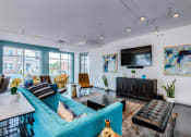 Thumbnail 20 of 35 - a living room with a blue couch and a tv on the wall at East 51 At Rocketts Landing, Richmond, 23231