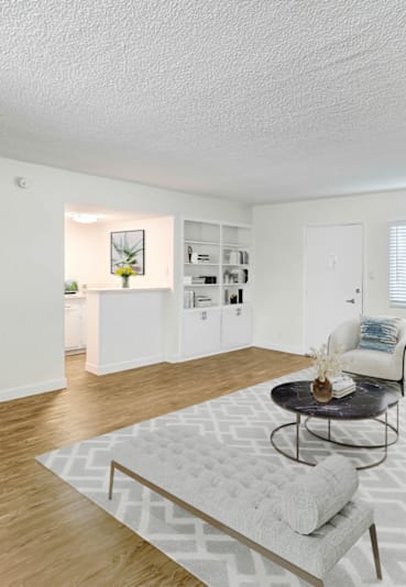 a living room with white furniture and a white rug