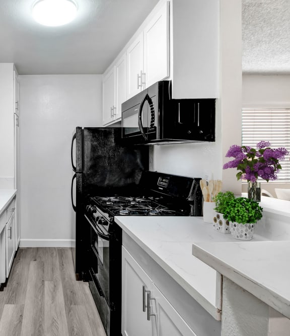 a renovated kitchen with white cabinets and black appliances