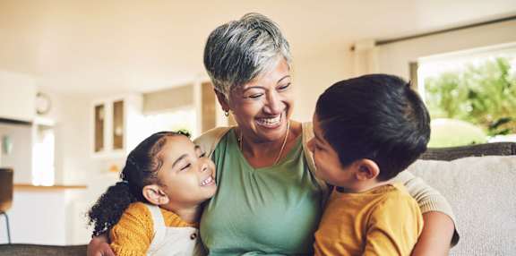 A woman with two children sitting on a couch.
