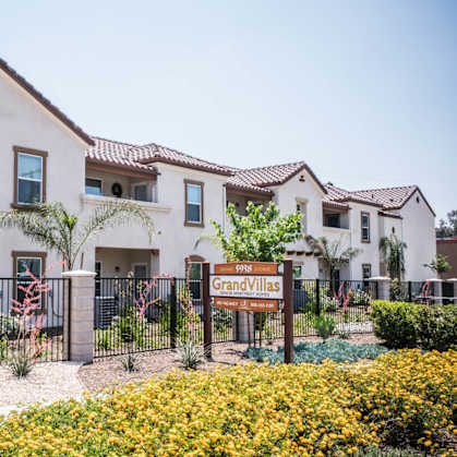A sign that says Grand Villas in front of a building.