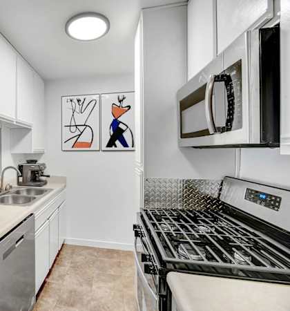 a kitchen with white cabinets and a stove and a sink