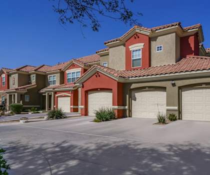 A row of houses with red roofs and garages.