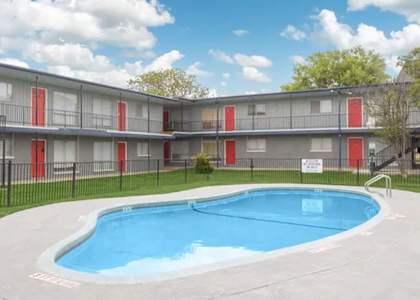 an apartment building with a pool in front of it