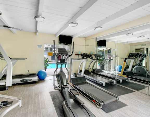 a gym with lots of treadmills and other exercise equipment