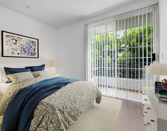 a bedroom with a bed and a large window