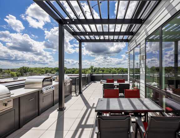 A patio with a table and chairs is covered by a roof.