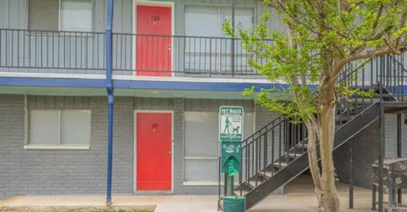 two red doors and a green parking meter in front of a building