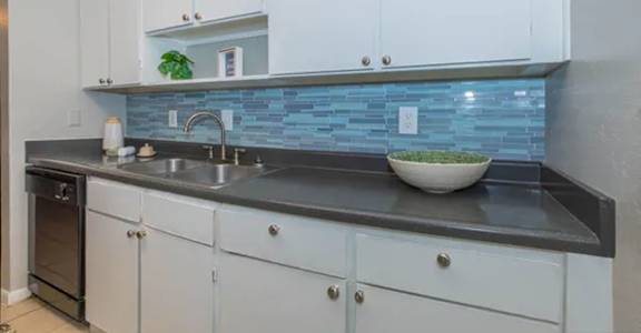 a kitchen with white cabinets and a sink and a counter top