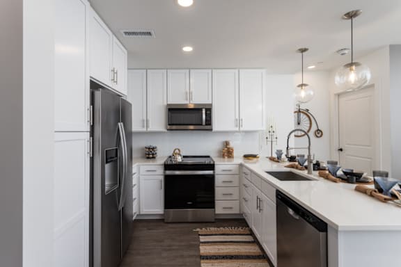 A modern kitchen with white cabinets and stainless-appliances at 2020 Providence in Huntsville, AL