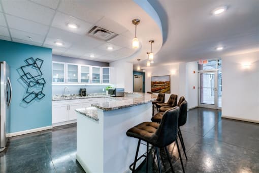 a kitchen with a long counter top and a bunch of chairs in front of it