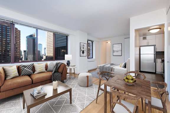 A modern living room with a brown sofa and a wooden coffee table at The Ellington Apartments, New York, NY, 10019