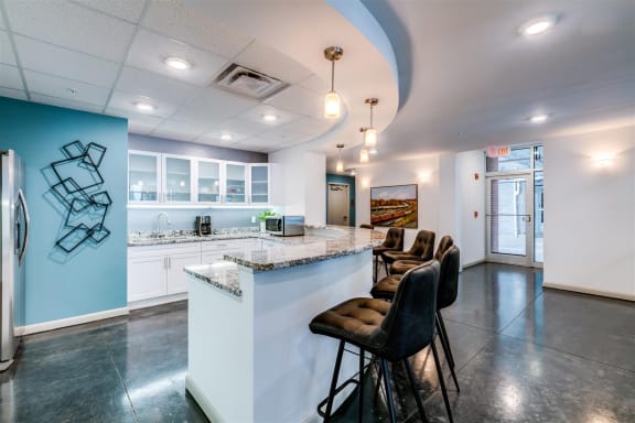 a kitchen with a long counter top and a bunch of chairs in front of it at East 51 At Rocketts Landing, Richmond, 23231