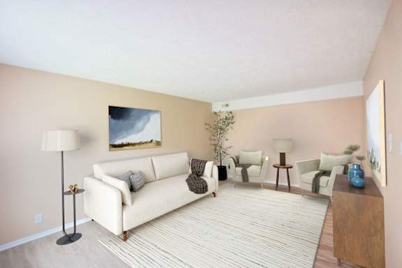 A living room with a white couch and a painting on the wall.