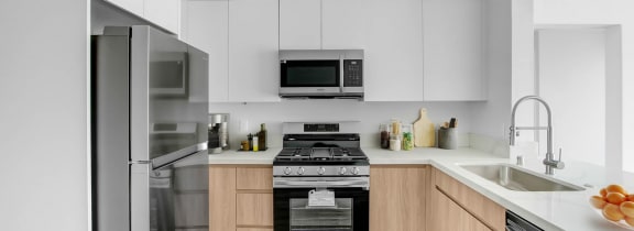 a modern kitchen with stainless steel appliances and white cabinets
