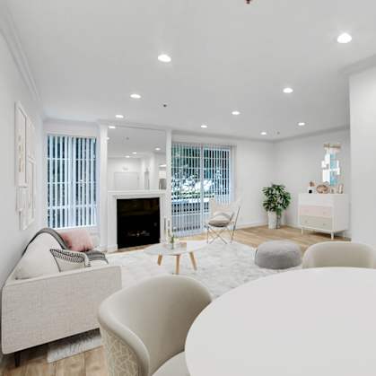 a living room with a round white table and a kitchen