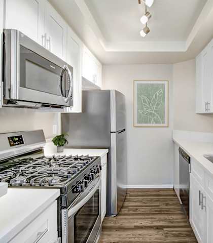 a kitchen with white cabinets and stainless steel appliances