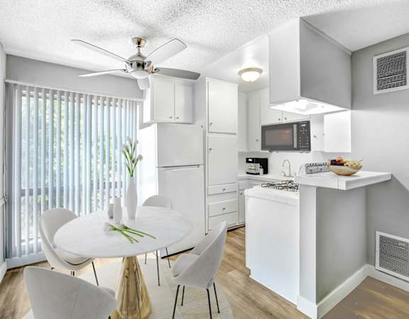 an open kitchen and dining room with a white table and chairs