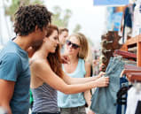 people looking at a pair of jeans at an outdoor market