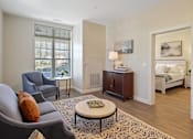 Thumbnail 2 of 5 - a living room with a couch and a coffee table and a bedroom at White Springs Senior Living, Warrenton, VA 20186