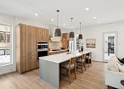 Thumbnail 18 of 51 - A modern kitchen with wooden cabinets and a white island.