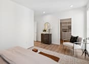 Thumbnail 6 of 51 - A bedroom with a bed, chair, and cabinet.