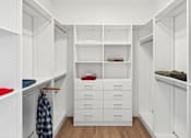 Thumbnail 5 of 51 - A white walk in closet with drawers and shelves.
