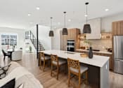 Thumbnail 17 of 51 - A modern kitchen with a dining table and chairs.