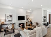 Thumbnail 16 of 51 - A modern living room with a fireplace and a grey couch.