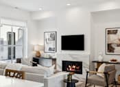 Thumbnail 13 of 51 - A modern living room with a fireplace and a flat screen TV.