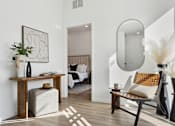 Thumbnail 26 of 51 - A modern living room with a wooden table and a large mirror on the wall.