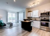 Thumbnail 15 of 35 - a kitchen with a center island next to a stove top oven at East 51 At Rocketts Landing, Richmond, 23231