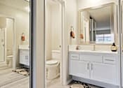Thumbnail 11 of 33 - Single vanity area with white quartz counter tops, white cabinet, mirrored closet door and bathroom on the left