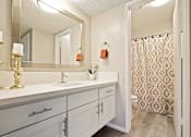 Thumbnail 14 of 33 - Long single vanity area with white quartz counter tops, white cabinet, bathroom on the right