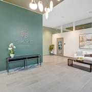 a lobby with a green wall and a couch and a table