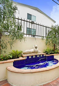 A small pool with a statue of a dog in the middle of it.