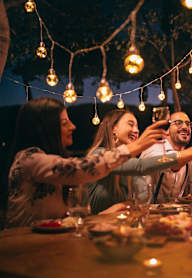 A group of people toasting with drinks at a dinner table.