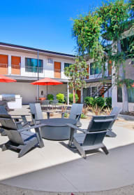 a patio with a table and chairs in front of a building