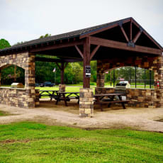 a picnic shelter with picnic tables in a park
