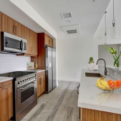 a kitchen with wooden cabinets and white countertops