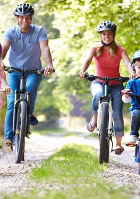a family riding bikes on a dirt path