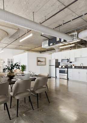 A modern dining room with a long table and chairs.